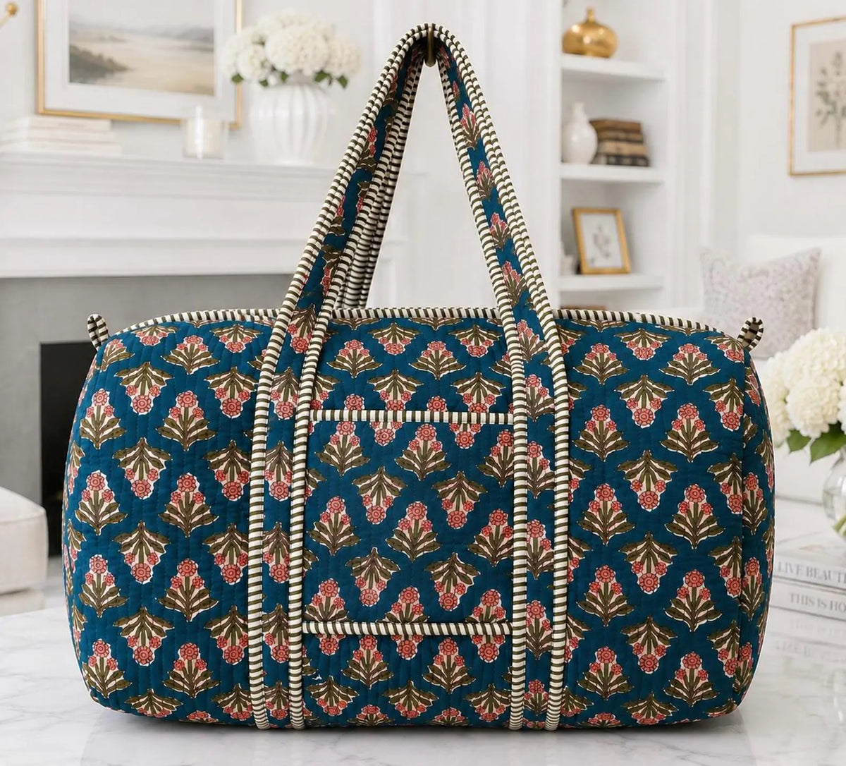 Teal blue floral block print quilted cotton duffle bag with black and white striped handles